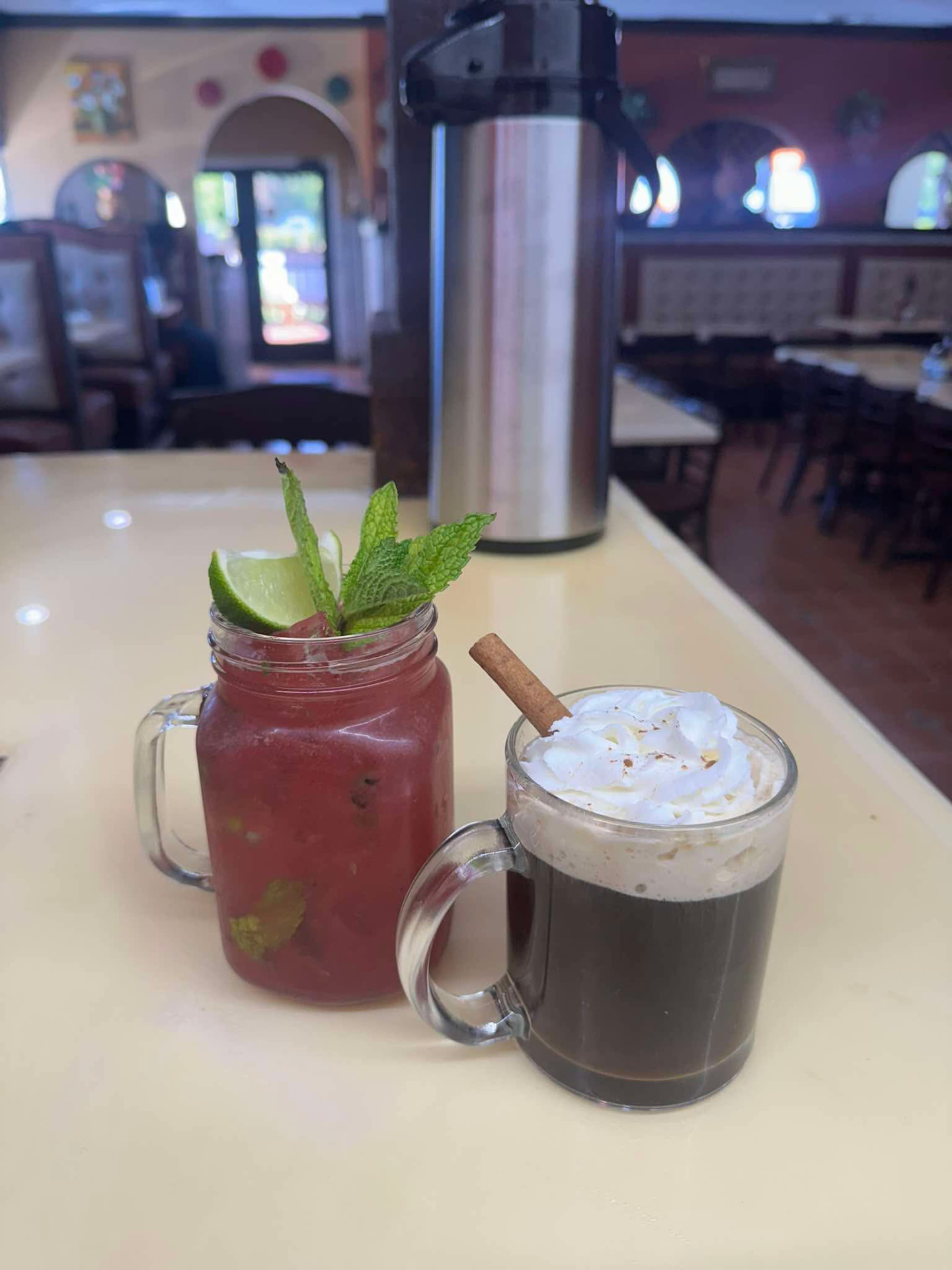 Watermelon agua fresca with mint and lime beside a café topped with whipped cream and cinnamon
